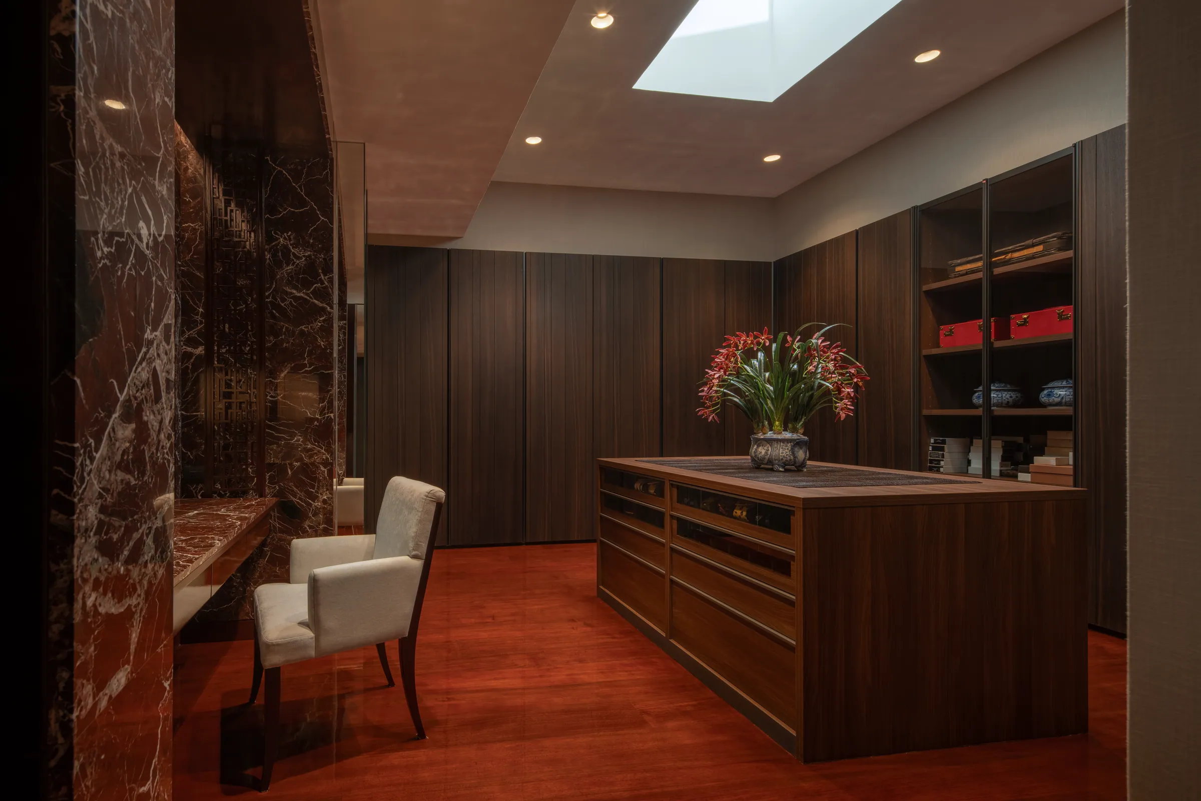 Walk-in closet of Bedroom 3 — dark wood cabinetry with white marble counters.
