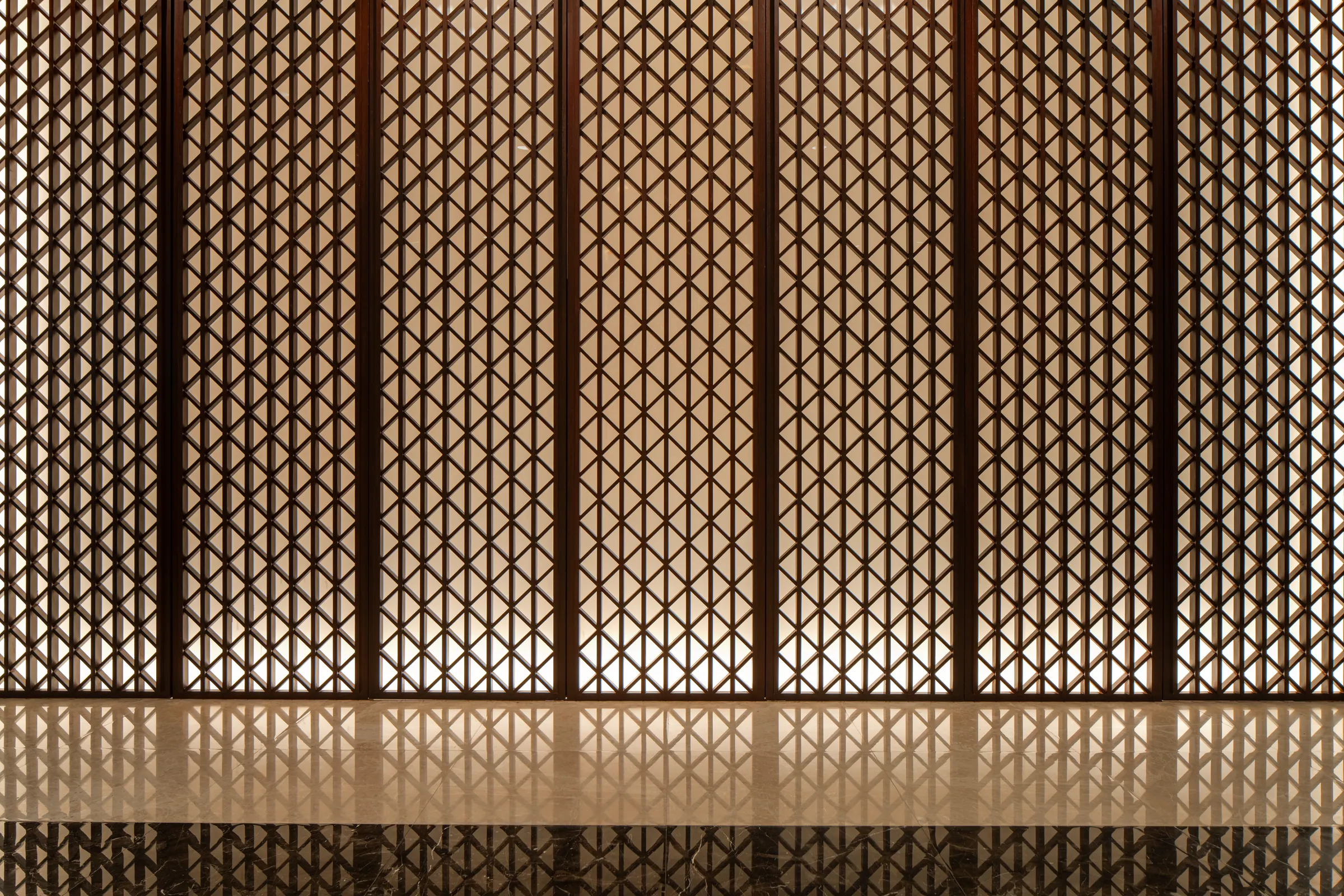 Detail of the geometric perforated wood entry screen at Khon Kaen Residence.
