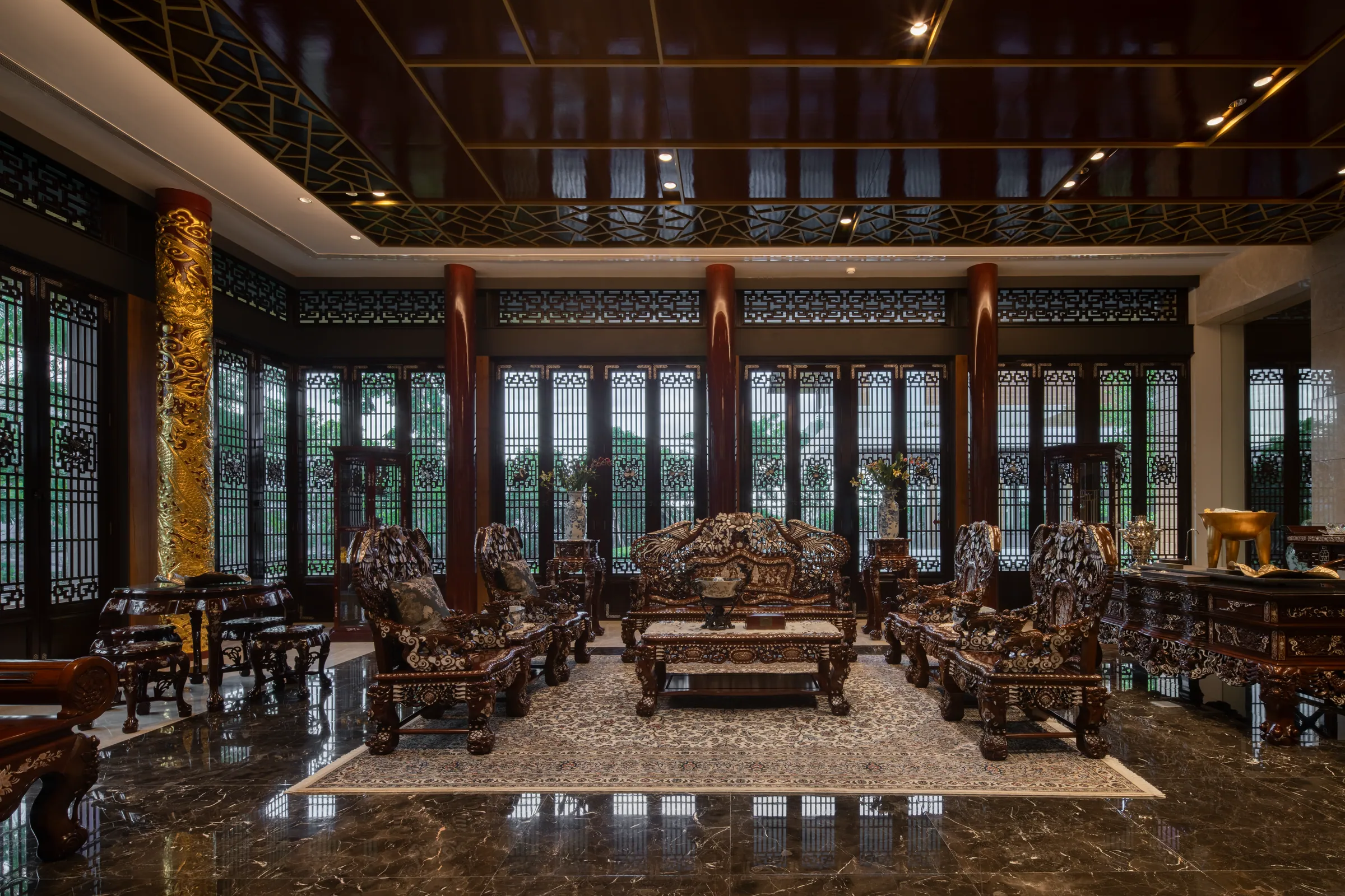 Living Room 1 — lacquered classical hall with carved hardwood furniture and gold-accented fretwork.