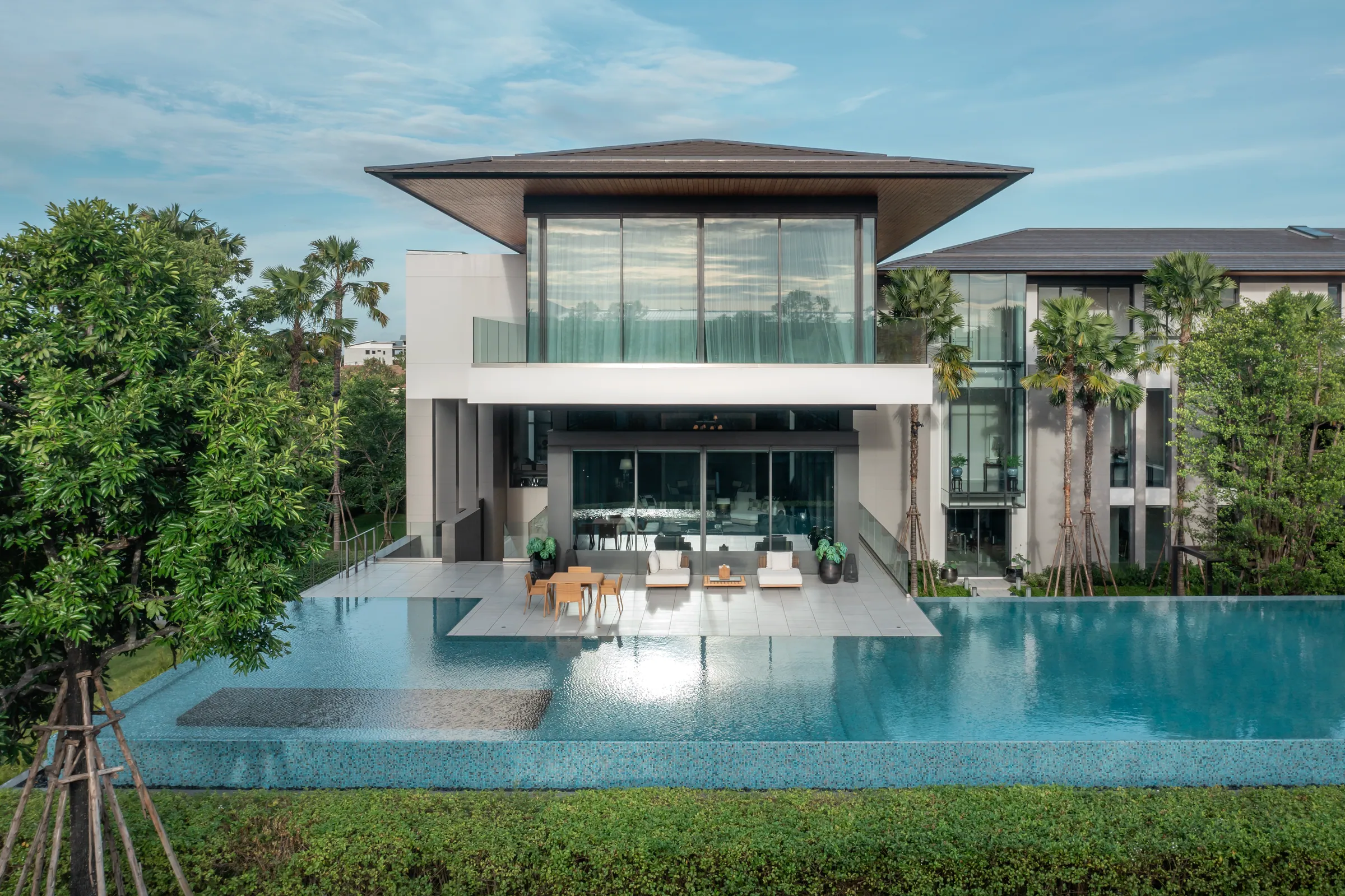 Cantilevered pool pavilion at Khon Kaen Residence with horizontal blade roof over the water.
