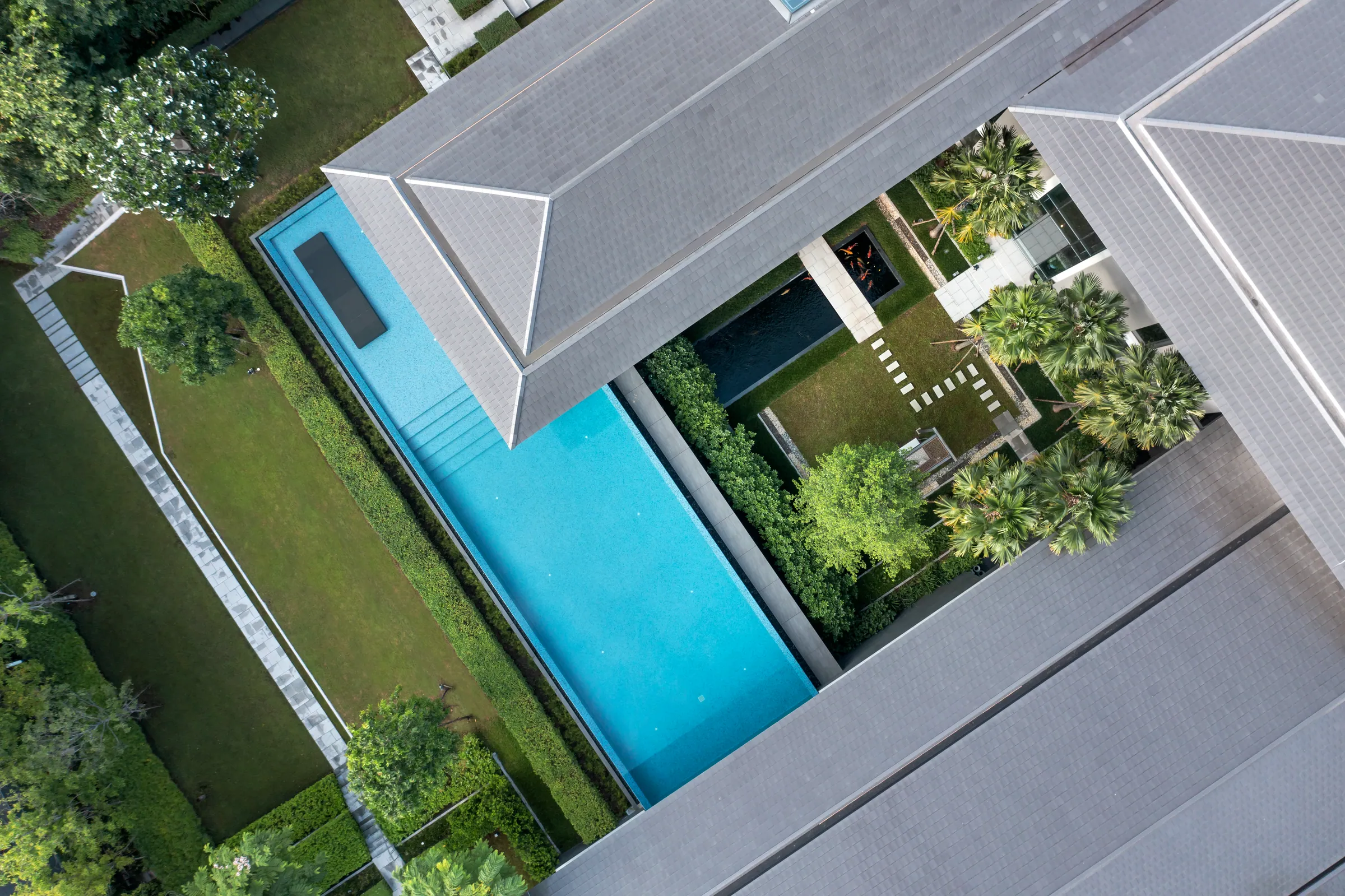 Overhead drone view of Khon Kaen Residence — the rectangular pool reads as a pure plane of turquoise.