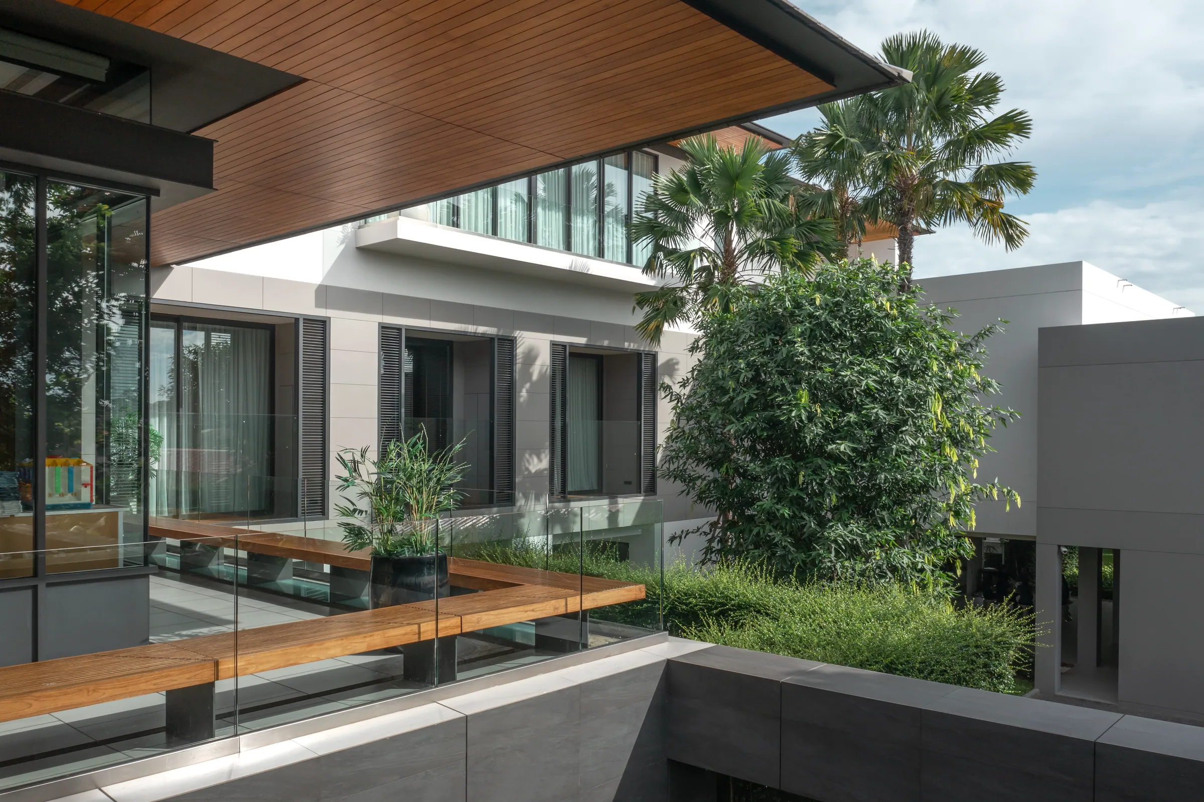Late-day exterior view of Khon Kaen Residence — pool, landscape, returning calm.