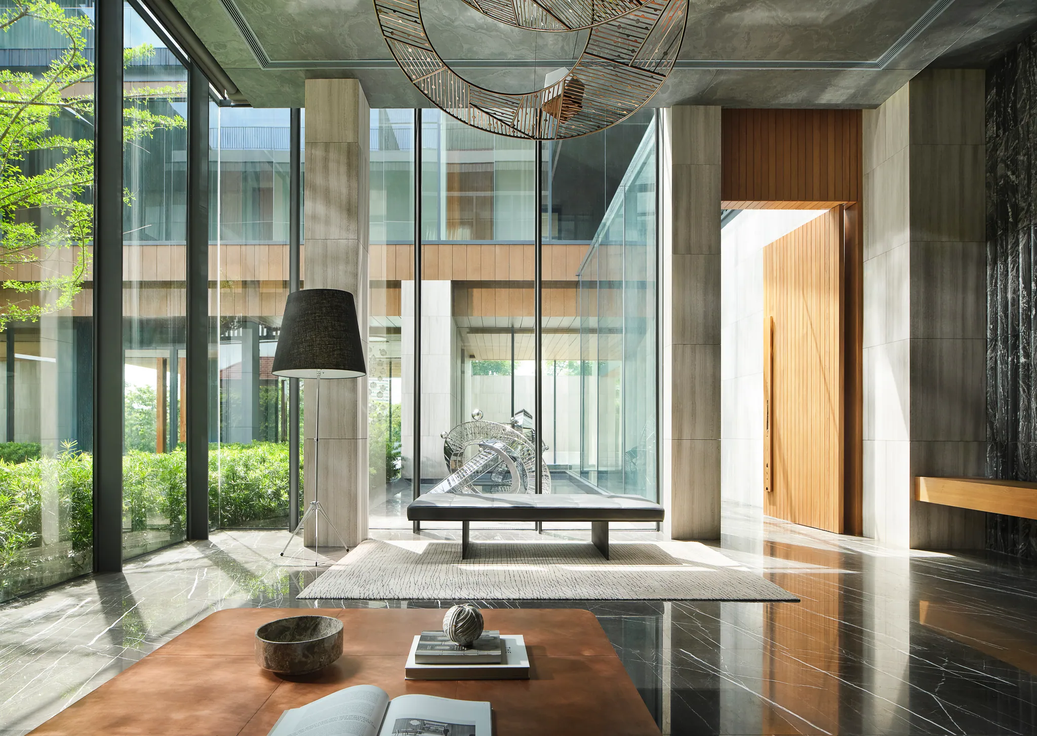 First-floor living room at Black Box Project — layered transparency, garden visible through wood screens, minimal furniture.
