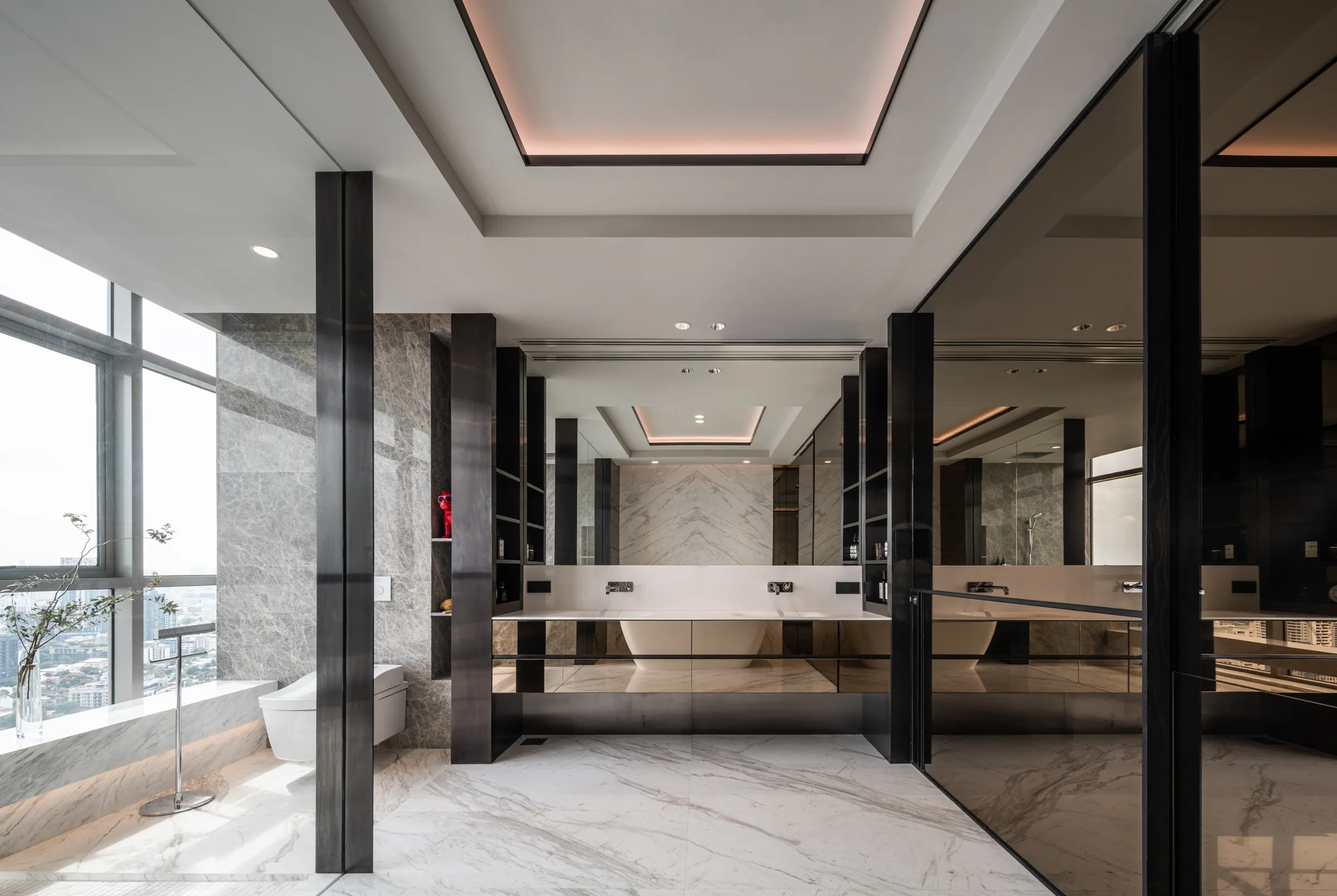 Master bathroom at Madison Penthouse — twin vanity running between dark mirrored columns, marble to the floor and walls throughout.