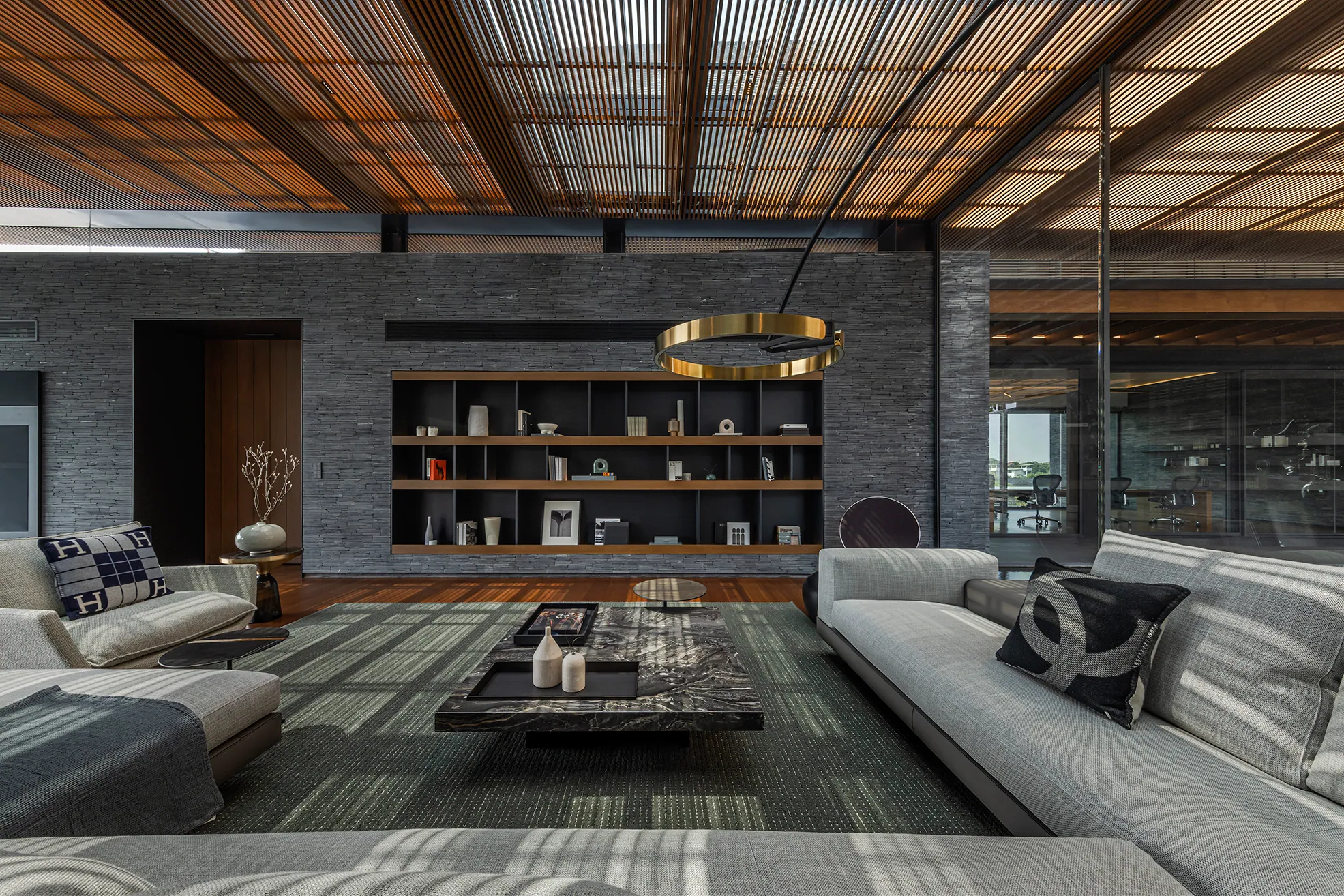 Dual-lounge gallery at Water House — built-in cabinetry, warm amber accent shelves, blue dusk light.