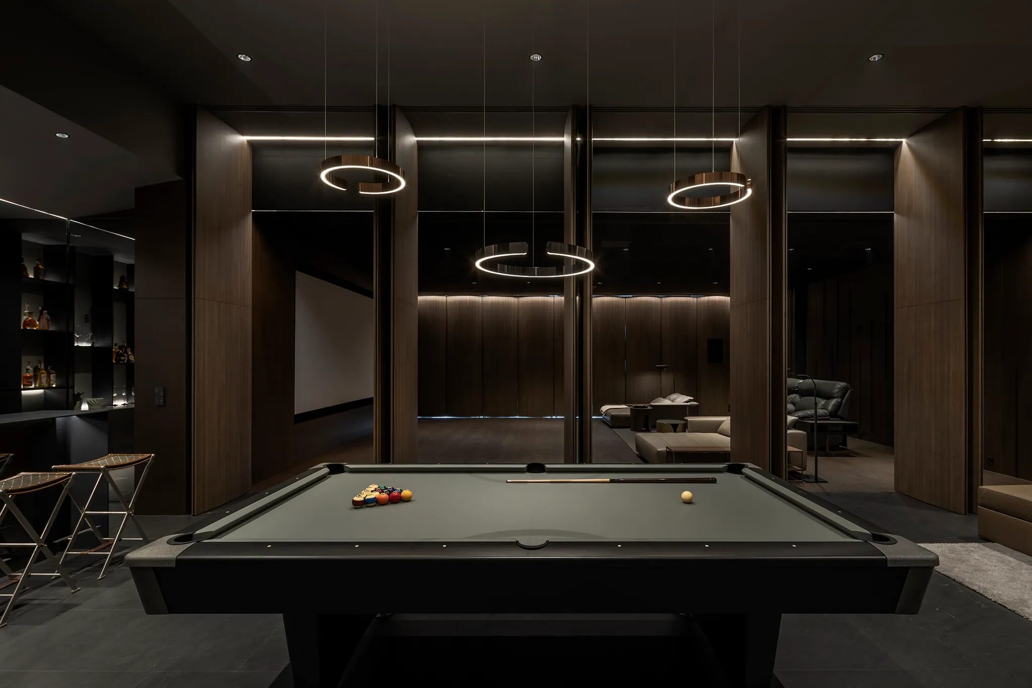 Bar detail at Water House — espresso cabinetry, amber-lit shelving.